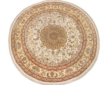 An oriental silk rug, diameter c. 216 cm.