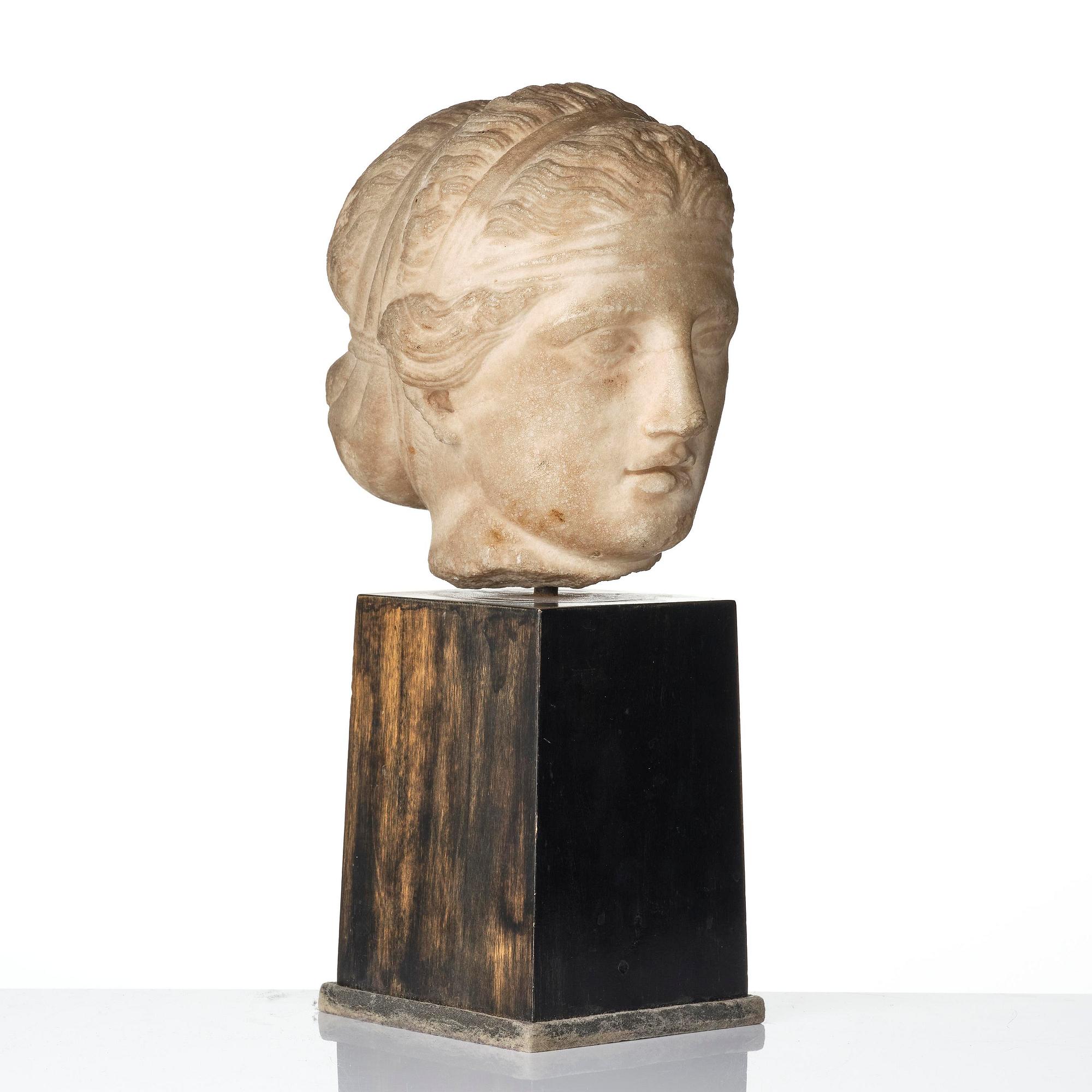 A Greek marble head of a deity wearing a Dionysiac fillet, Hellenistic style presumably 16th century.