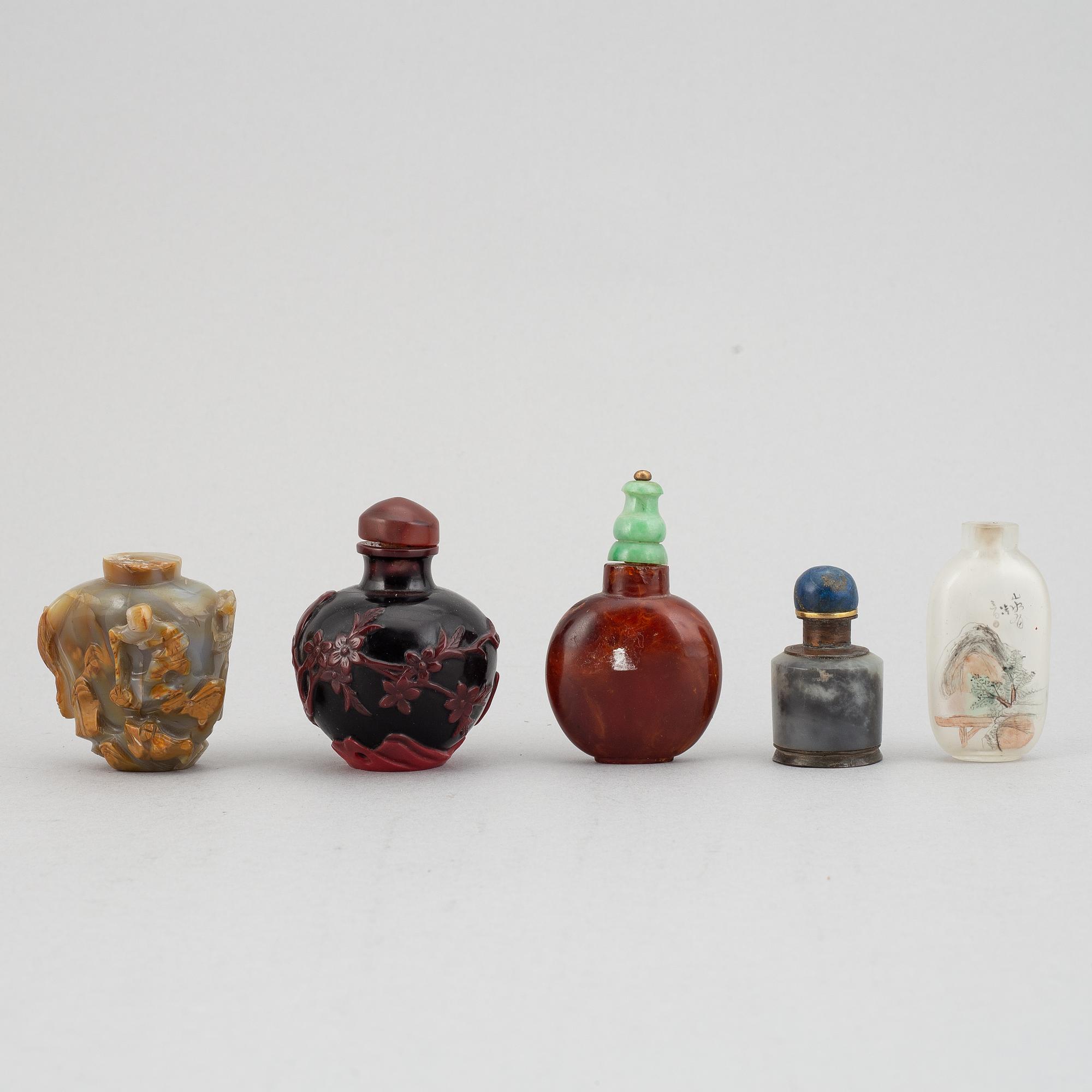 Five Chinese snuff bottles of different materials including stone and glass, 20th century.