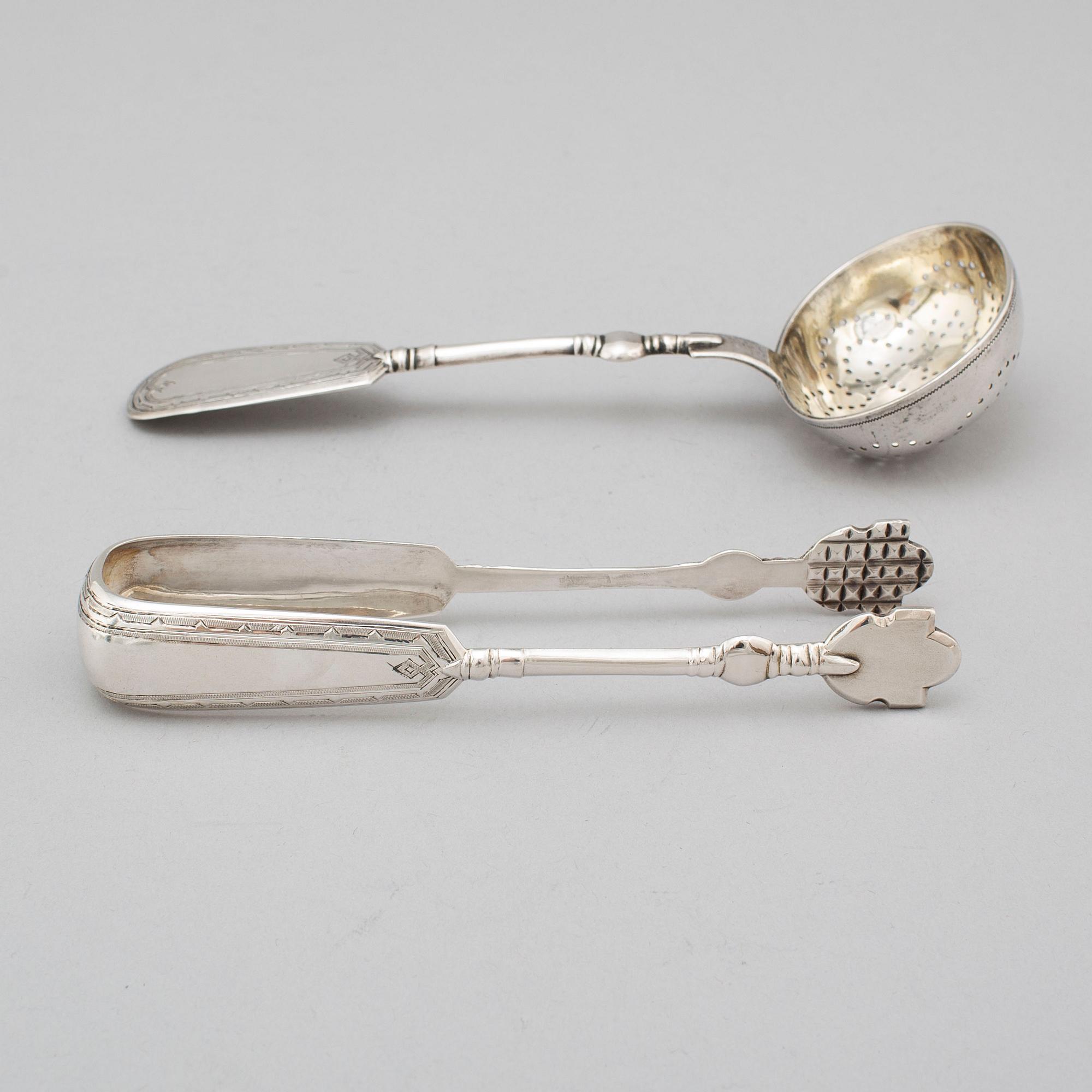 A Russian 19th century silver straining spoon and a pair of sugar tongs, St. Petersburg 1893.
