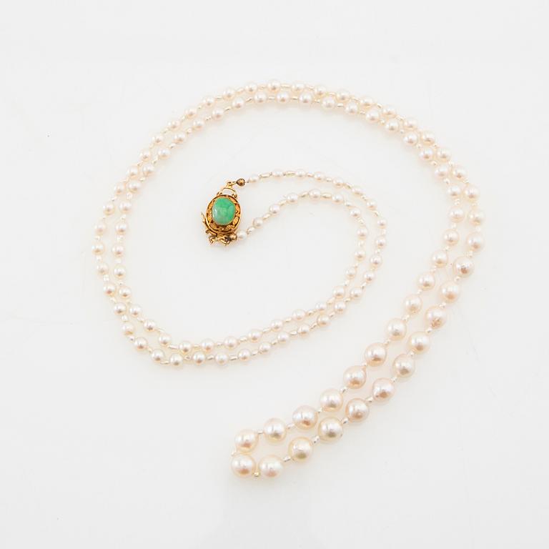 Necklace of cultured pearls with a clasp of 18K gold and cabochon-cut green stone.
