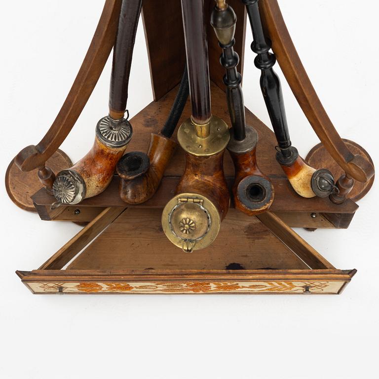 A pipestand and four pipes, circa 1900.