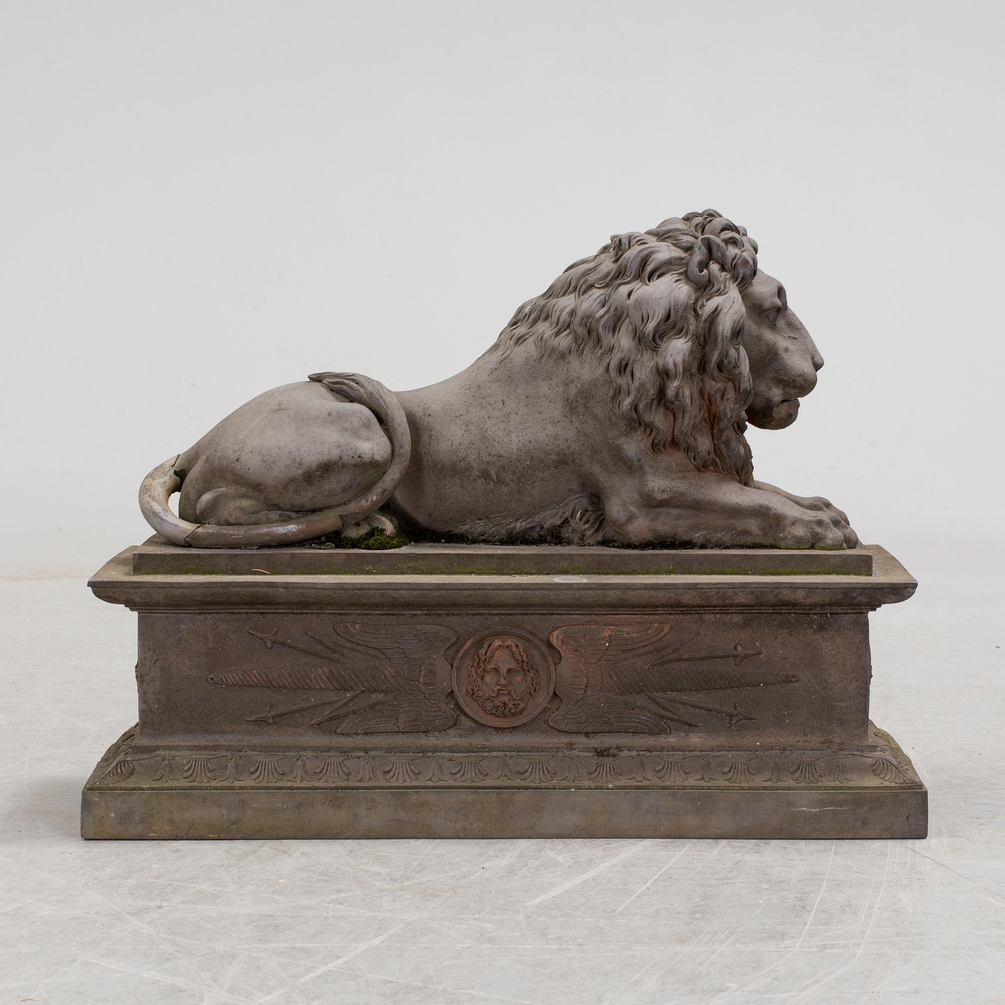 A SCULPTURE/ DECOR-ELEMENT, a lion on a plint, artificial stone, empire-style, late 1900s.