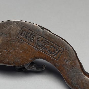 A bronze brush rest in the shape of a wave, Qing dynasty (1644-1912).