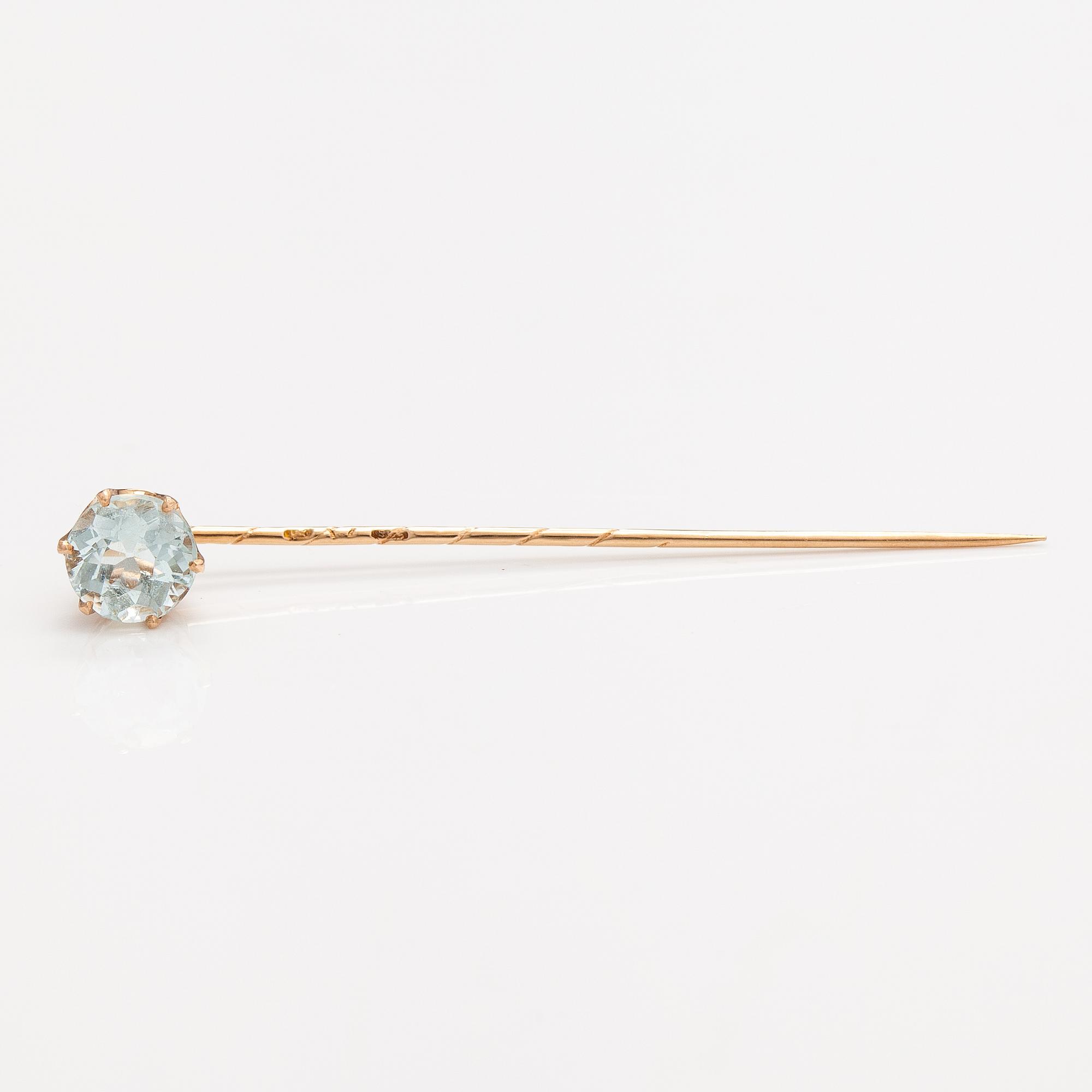 A 14K gold tiepin with a aquamarine.
