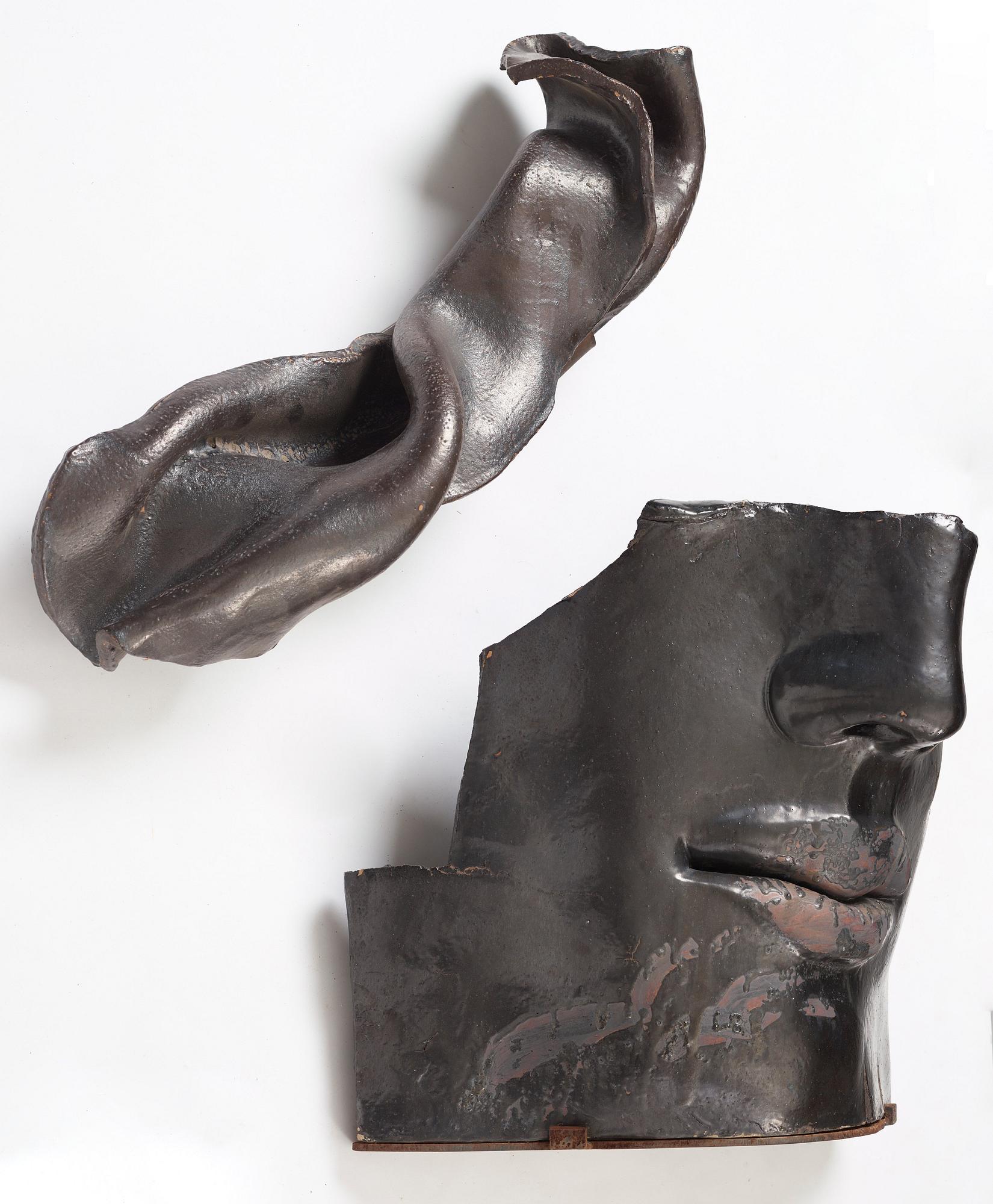 Hertha Hillfon, a black glazed stoneware wall sculpture in two parts of a face and a sky, executed in her own studio, Stockholm 1960s.