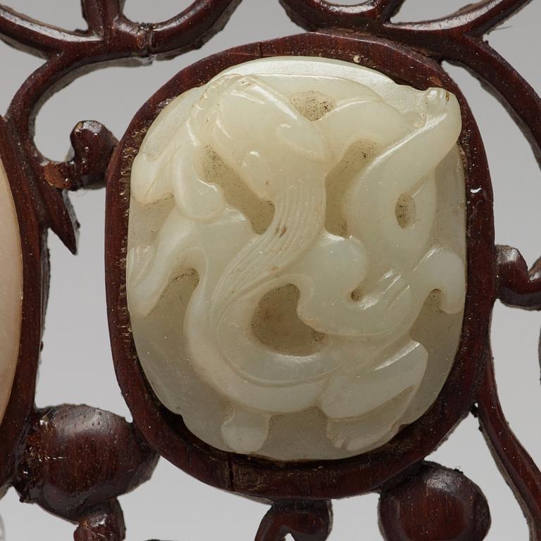 A set of four carved nephrite objects on a wooden frame, Qing dynasty (1664-1912).