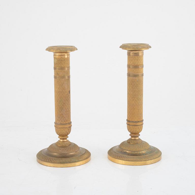 An Empire-style gilt bronze mantel clock and a pair of candlesticks, 20th century.