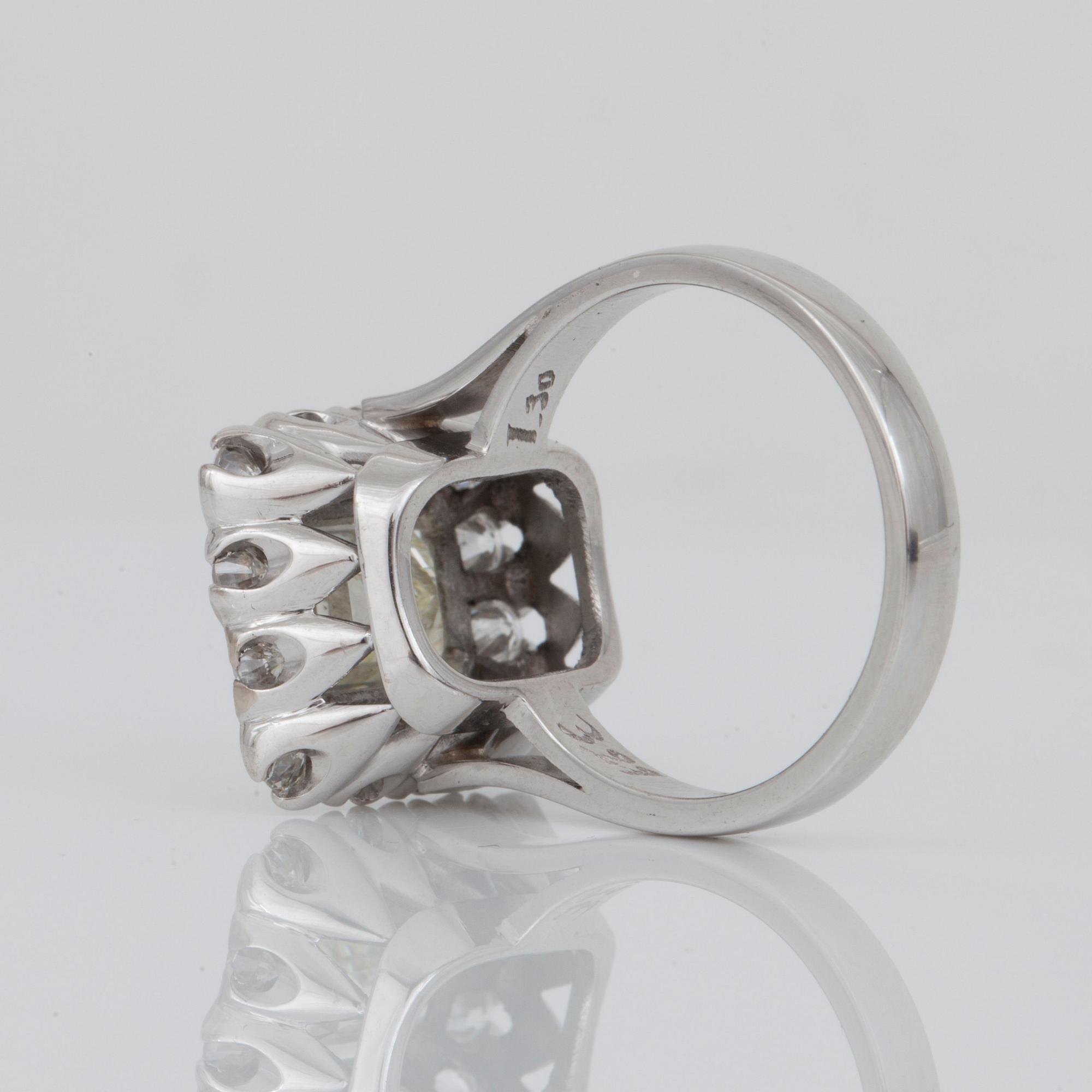 RING med baguetteslipad diamant, 3.21 ct enligt gravyr, inramad av 14 briljantslipade diamanter. Totalt 1.30 ct.