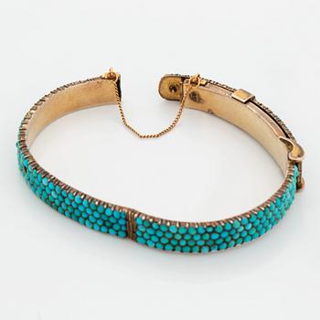 A silver and turquoise bracelet.