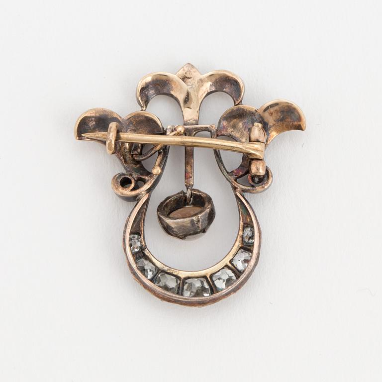 A brooch set with a mabé pearl and old-cut diamonds.