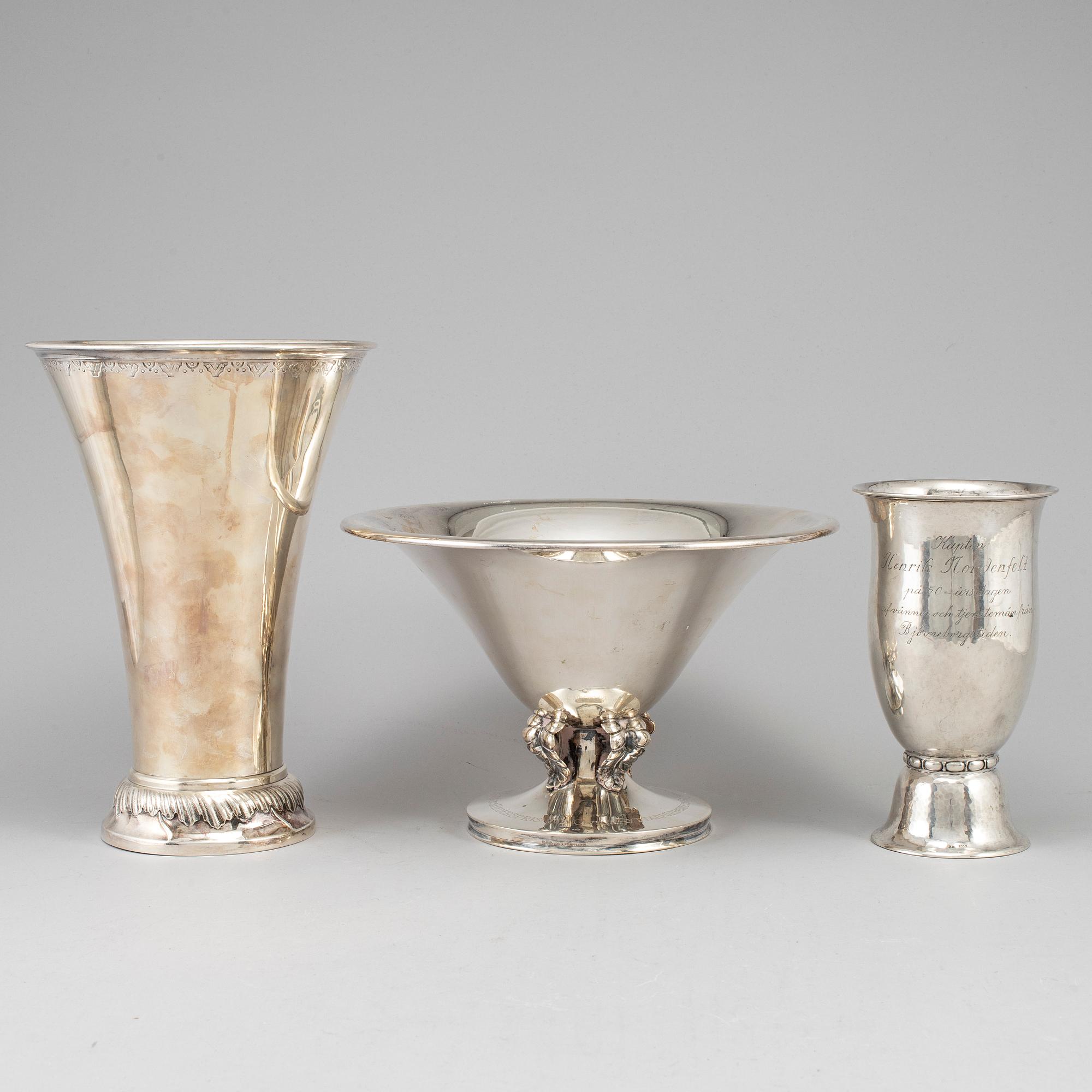 Two silver beakers and a bowl.