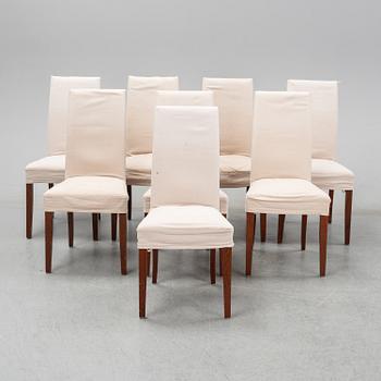 An stained oak dining table with eight chairs.