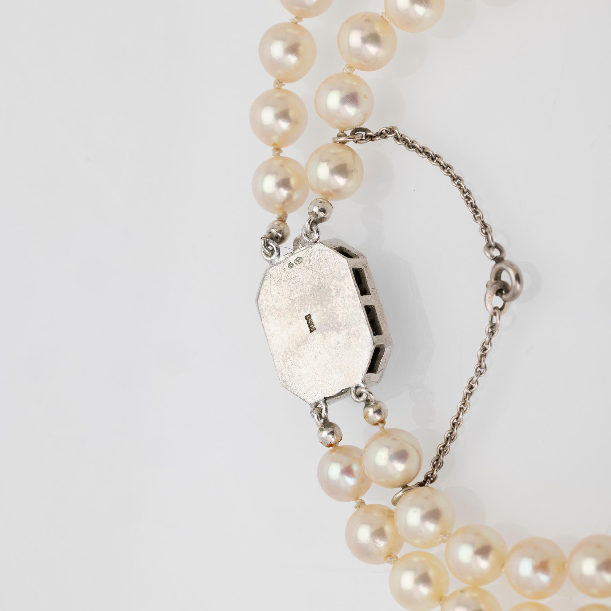 Two-row cultured pearl necklace with a silver and glass clasp.