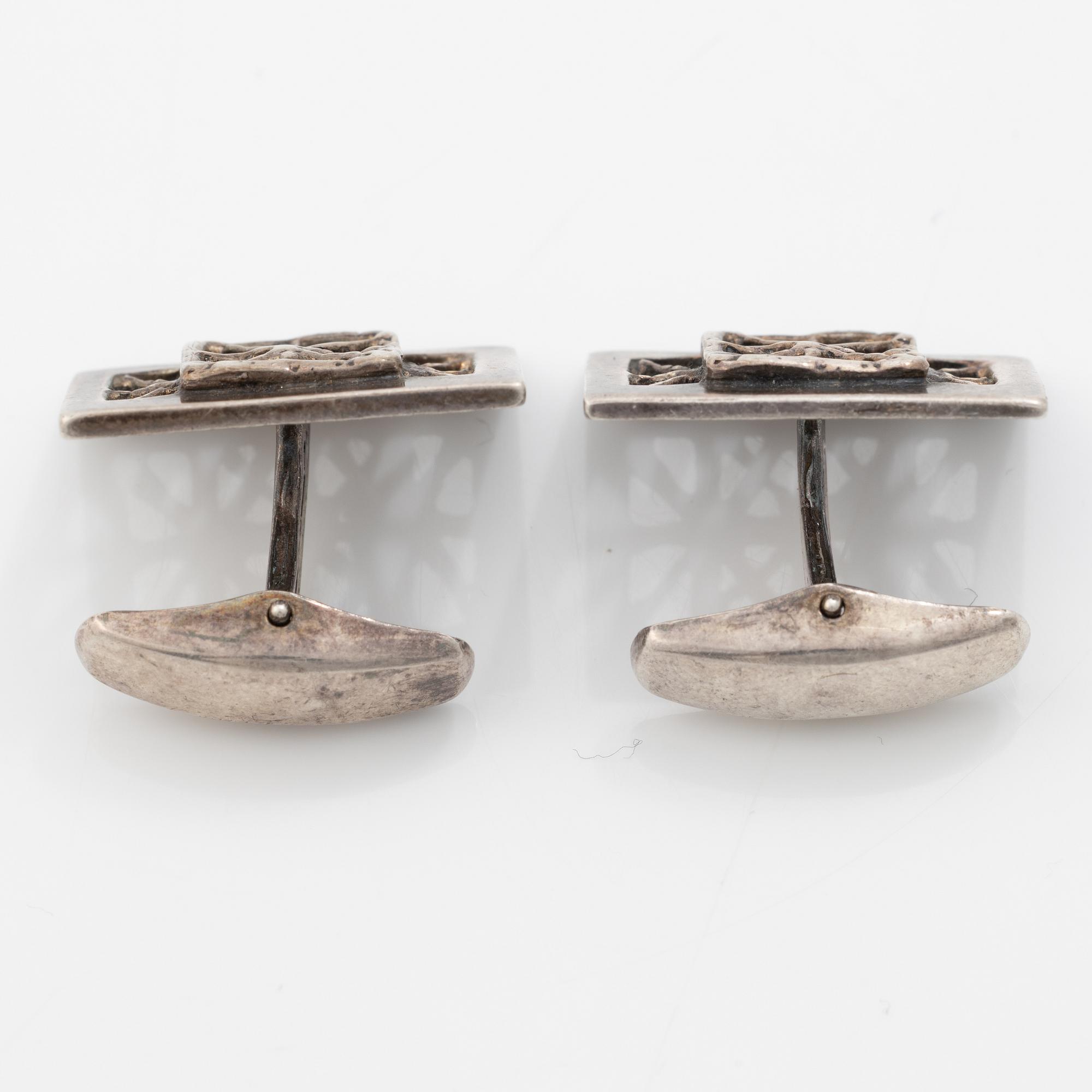 Four silver jewellery pieces: three brooches and a pair of cufflinks. With rose quartz and tiger’s eye. Finnish designers.