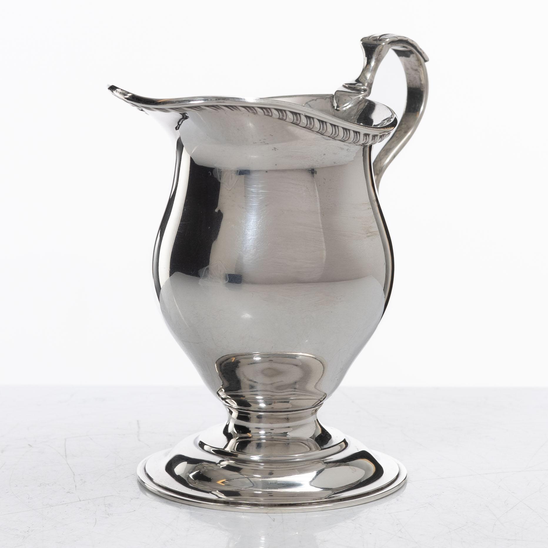 A silver cream jug, mark of S W Smith & Co, Birmingham, England 1929.