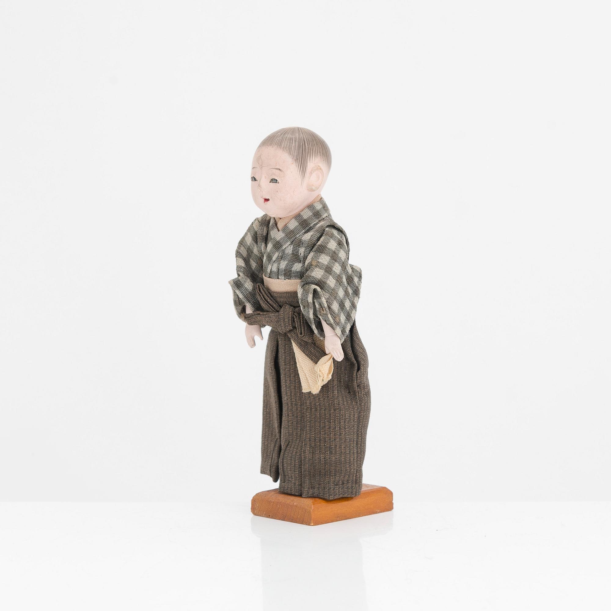 Five porcelain sake cups and a papier maché doll, Japan first half of the 20th century.