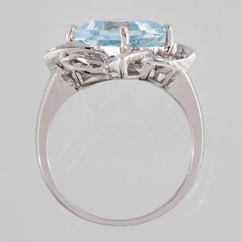 RING, 18K vitguld med carréslipad blå topas 4.07 ct samt baguett och briljantslipade diamanter 0.36 ct. Vikt 4,1 gram.