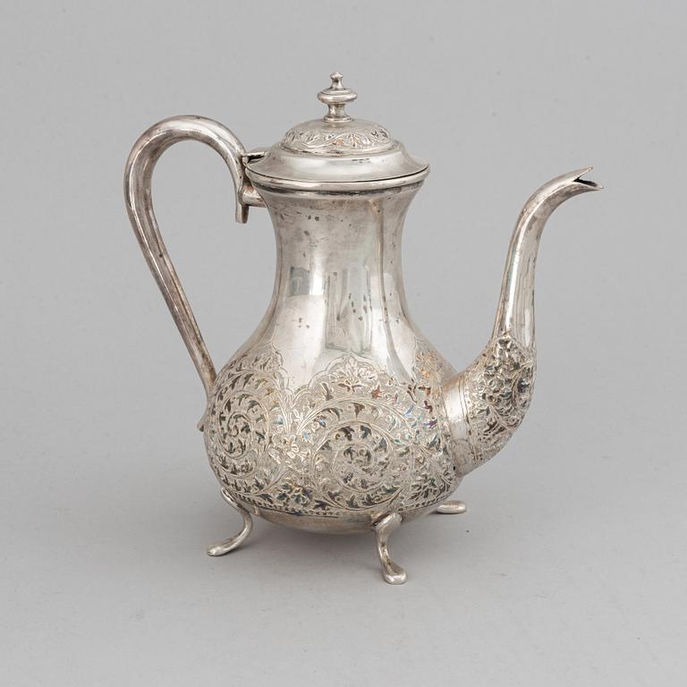 A Pakistan silver coffee pot, sugar bowl, sugar tongs and creamer.