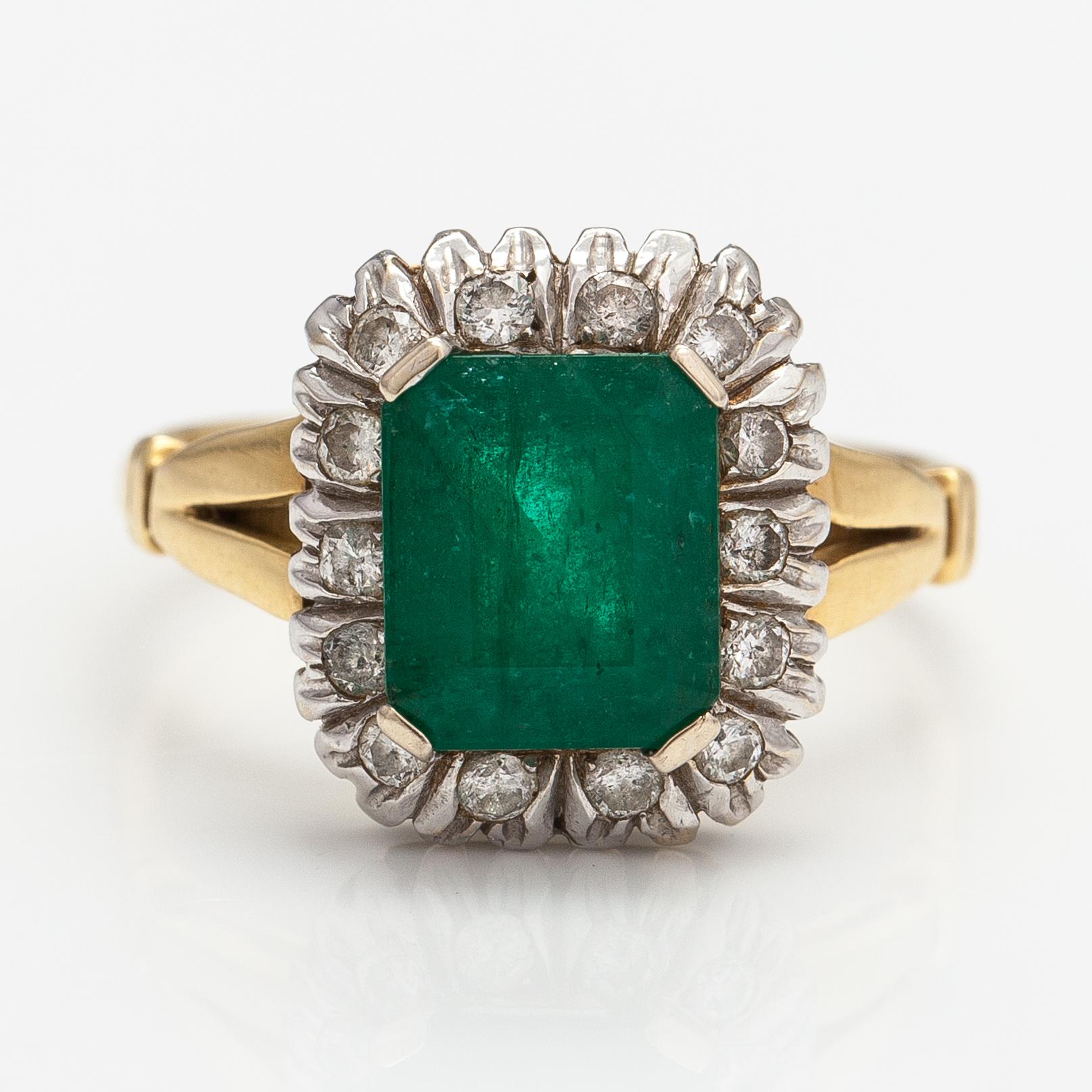 An 18K gold ring with diamonds ca. 0.21 ct and an emerald.