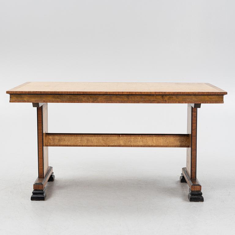 A 1930's birch and rosewood-veneered dining table.