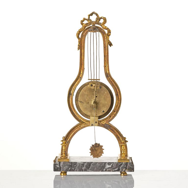 A French Louis XVI ormolu and marble lyre-shaped mantel clock, late 18th century.
