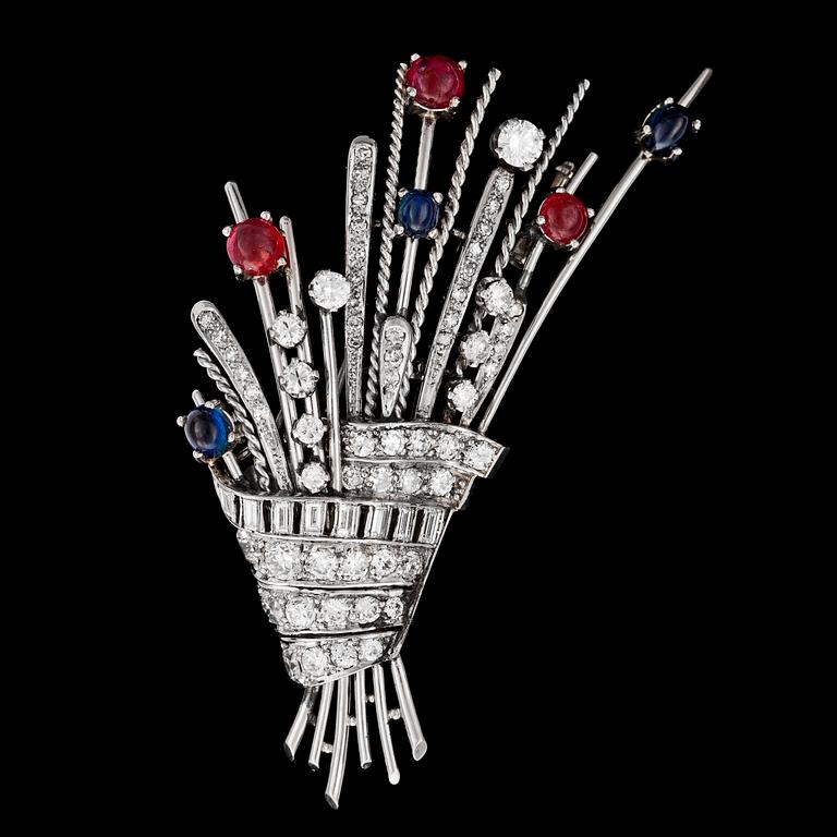 BROSCH, blå cabochonslipade safirer, rubiner med briljant- och baguetteslipade diamanter, tot. ca 3 ct. 1930-tal.