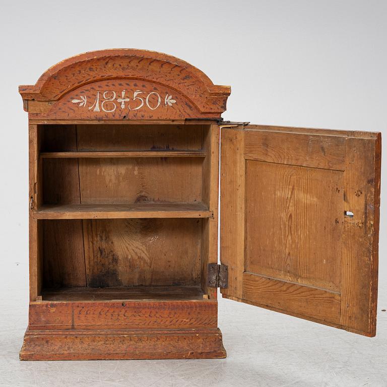 A hanging cabinet, dated 1850.