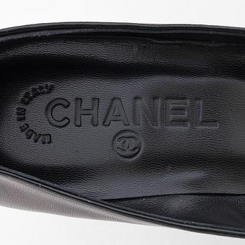 CHANEL, a pair of black leather pumps.