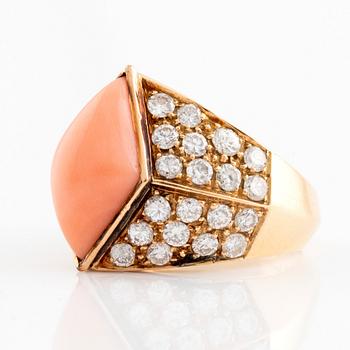 An 18K gold and coral ring set with round brilliant-cut diamonds.