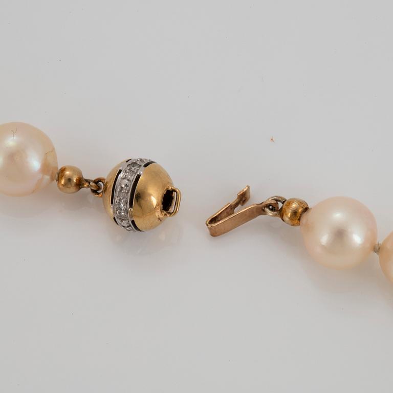 An 18K gold pendant with a cultured pearl necklace.