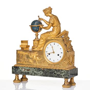 A patinated, ormolu, and marble French Empire figural mantel clock, early 19th century.