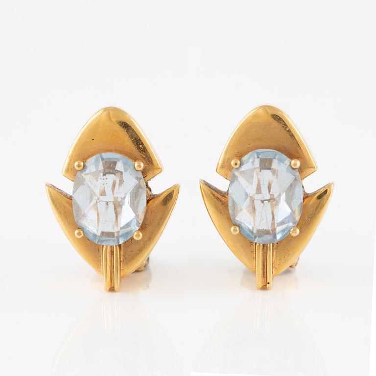 A pair of 18K gold earrings with faceted blue stones.