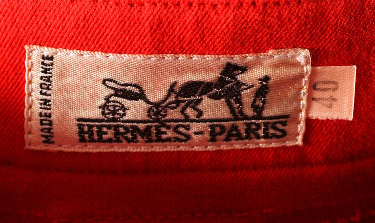 A pair of orange trousers by Hermès.