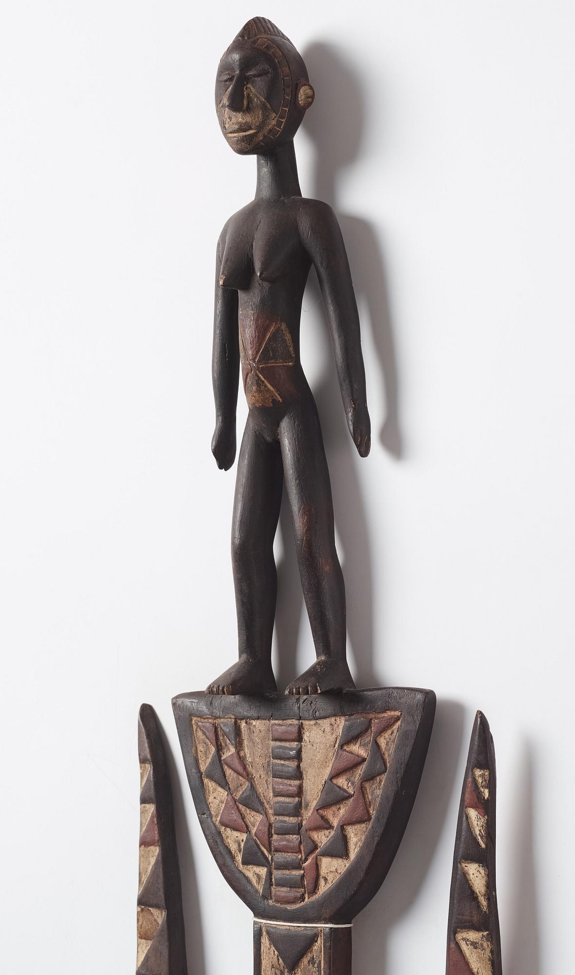 A sculptue and two masks reportedly from The Ivory coast, from the second half of the 20:th century.