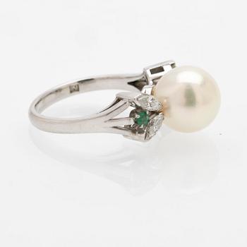 Platinum ring with a cultured pearl, emeralds and diamonds.