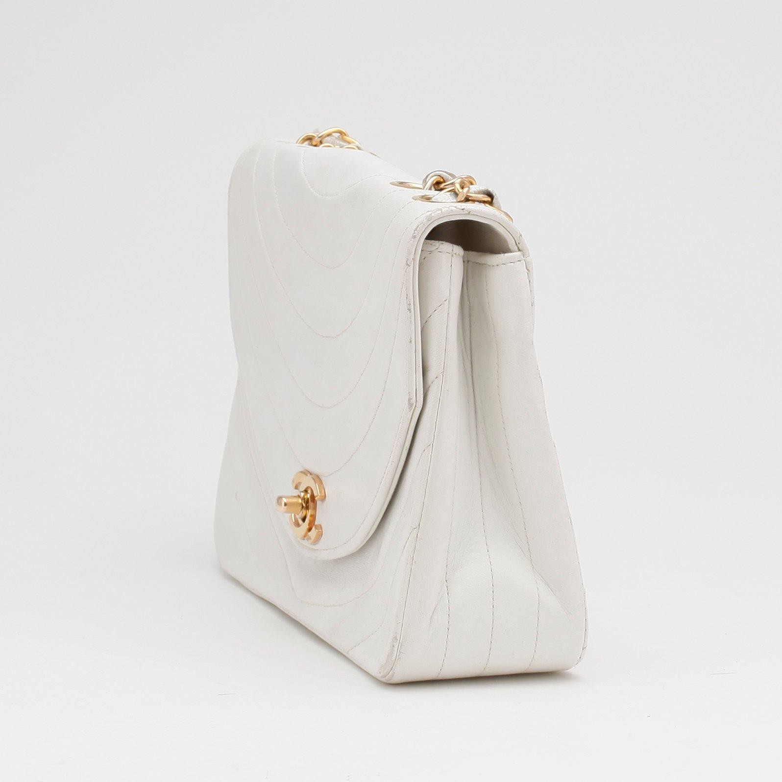 CHANEL, a white leather shoulder bag.