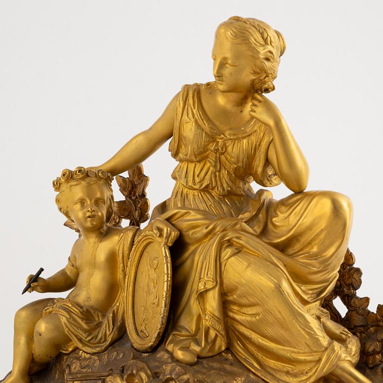 A table clock and a pair of candelabras, Louis XVI-style, France, beginning of the 20th century.