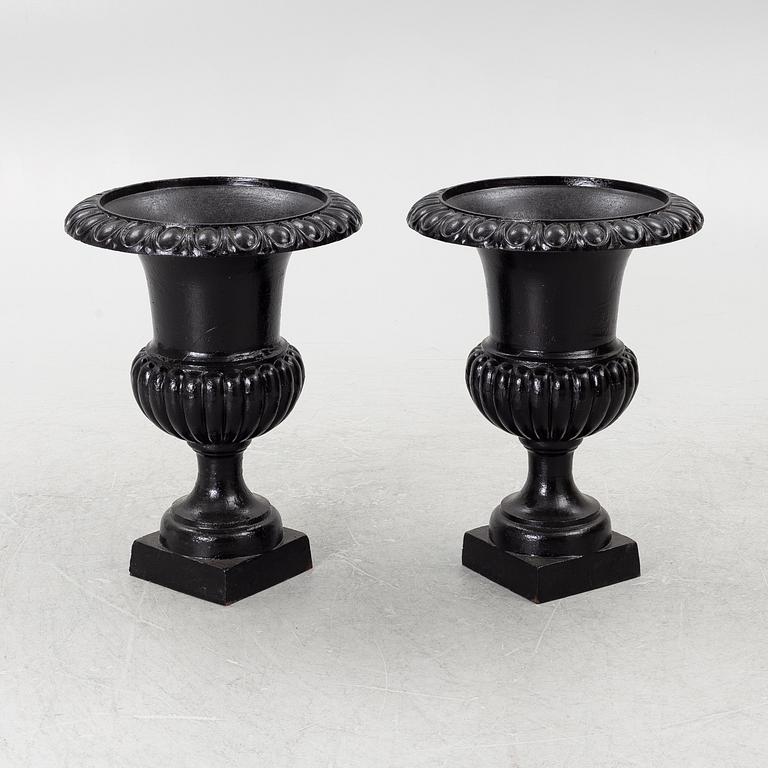 A pair of cast iron garden urns, 20th century.