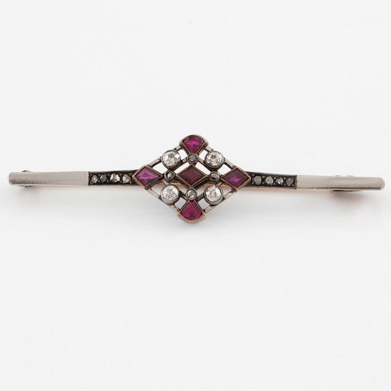 Brooch platinum and 14K gold set with old- and rose-cut diamonds and red stones.