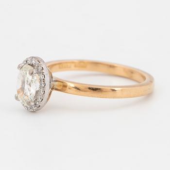 An 18k gold ring set with an oval brilliant-cut diamond.