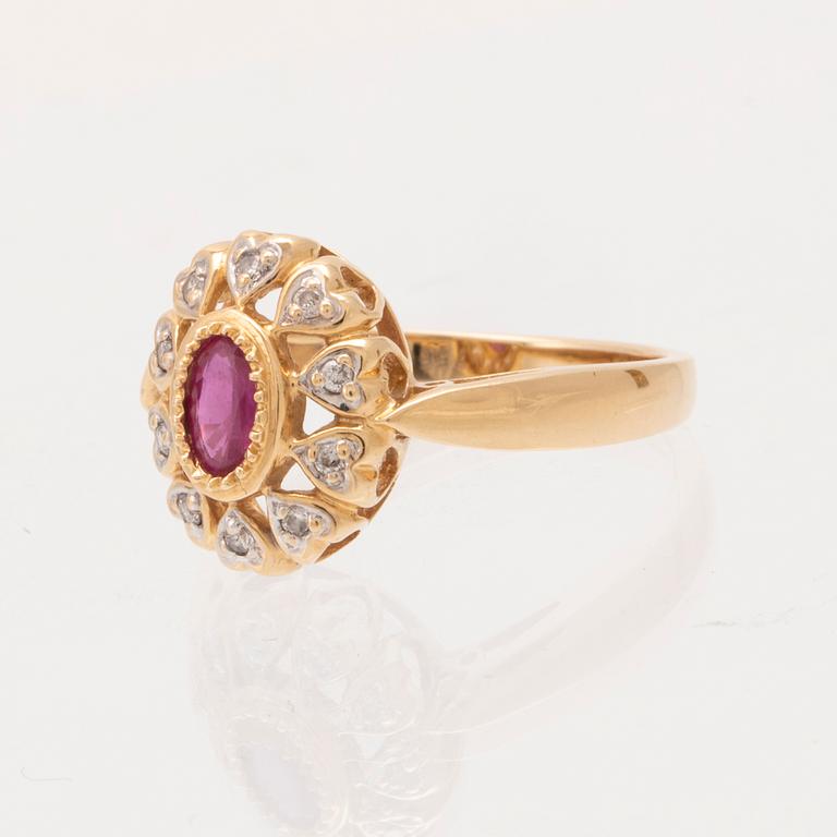 An 18K gold ring set with an oval brilliant cut ruby and round brilliant cut diamonds.