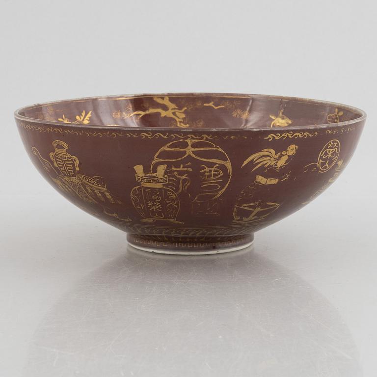 A brown glazed bowl with gilded decoration of animals and antiques, Qing dynasty, 19th century.