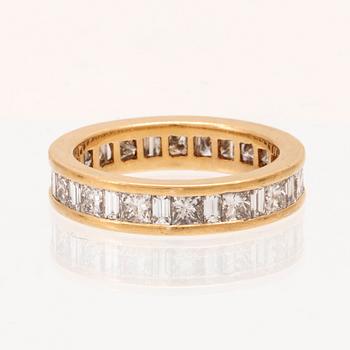 An 18K gold eternity ring set with baguette and princess cut diamonds by Hartmann's Denmark.