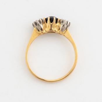 An 18K gold ring set with a sapphire and old-cut diamonds.