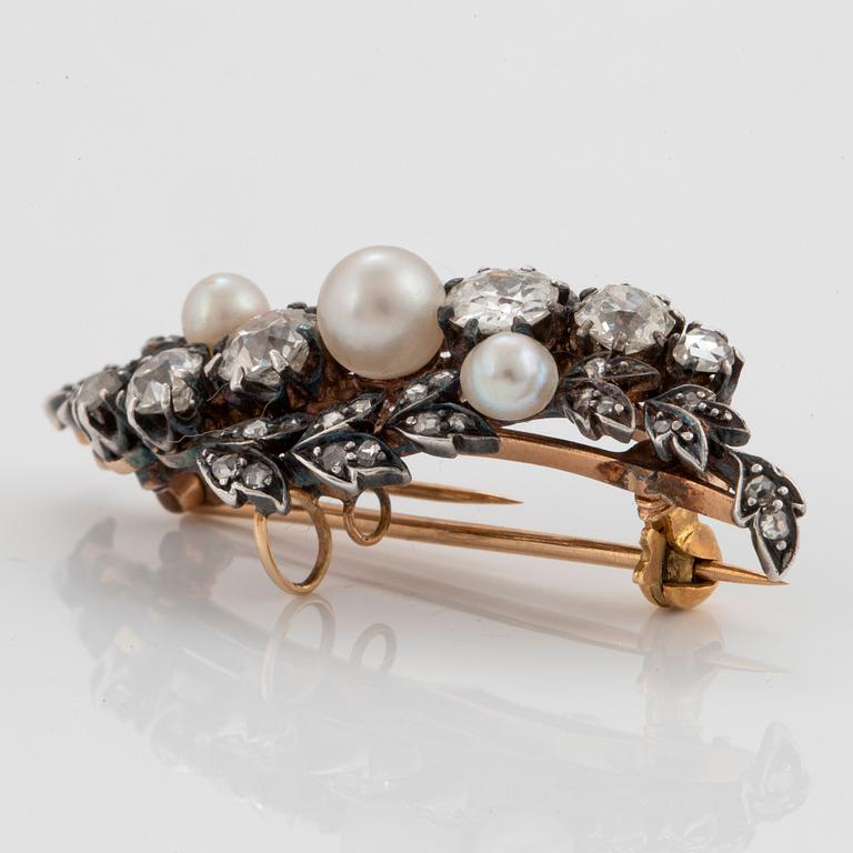 A silver and 14K gold brooch set with old- and rose-cut diamonds and pearls.
