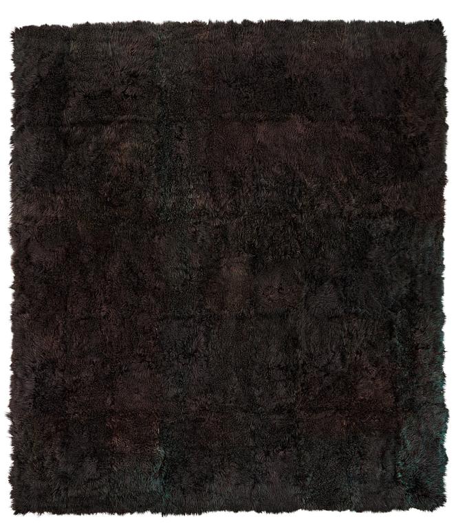 A carpet, sheepskins, black dark brown green melange, ca 547 x 492-498 cm.