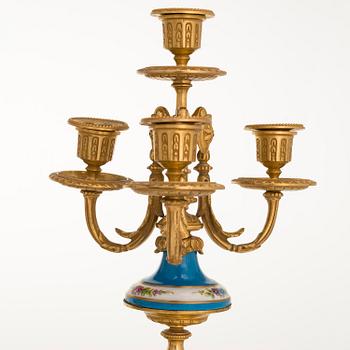 A mid-19th-century French gilt-brass mantel clock with a pair of candelabra by Dussault.