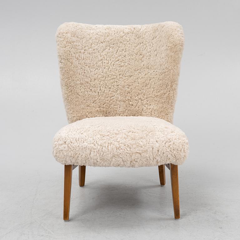 A mid 20th Century easy chair with sheepskin upholstery.