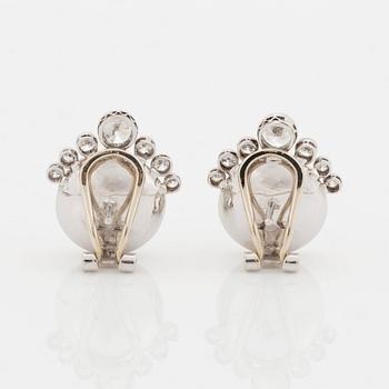 A pair of 18K white gold earrings set with mabe pearls and round brilliant-cut diamonds.